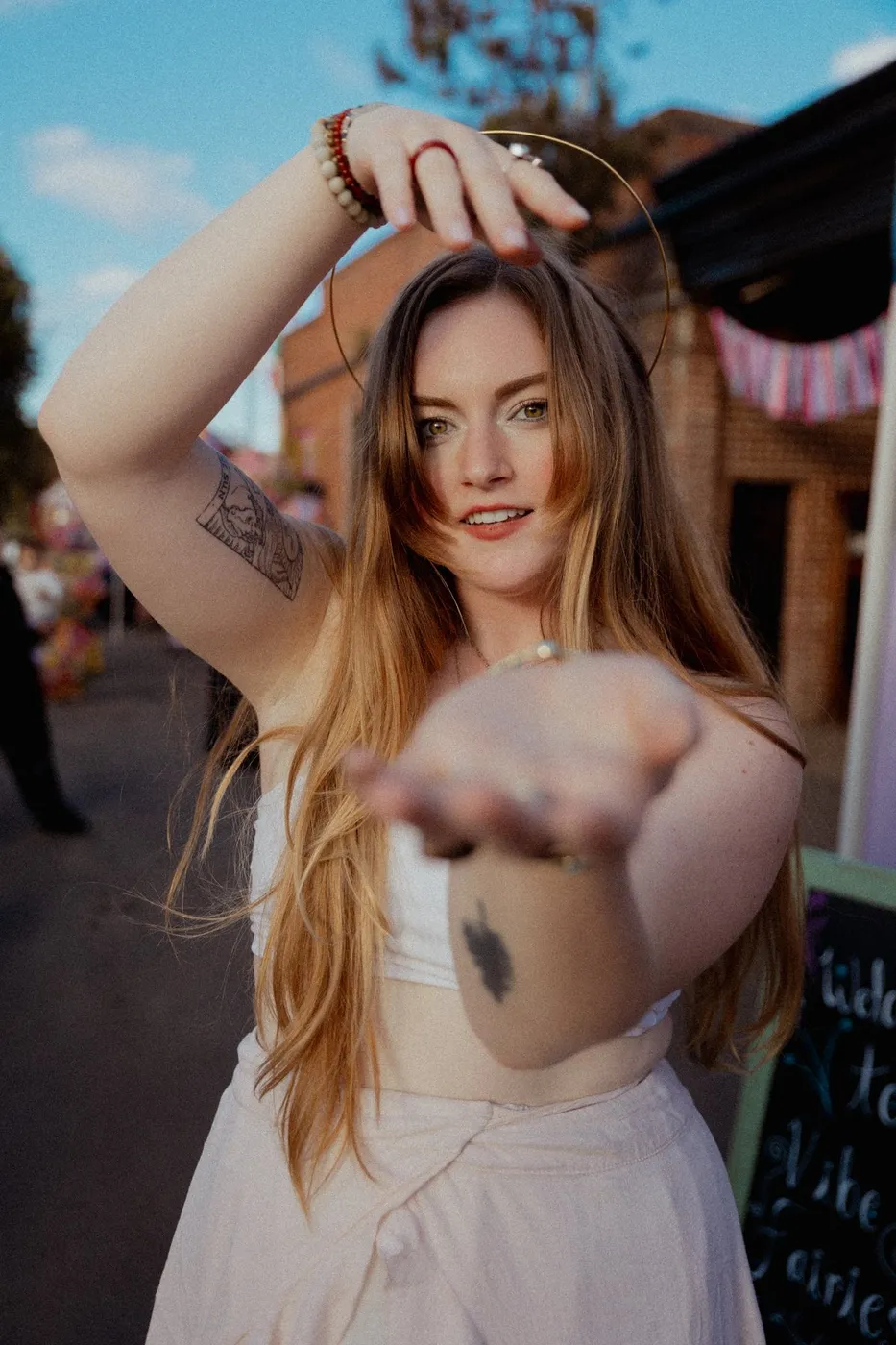 A woman in a gold halo headpiece dancing toward the camera at Press Pause